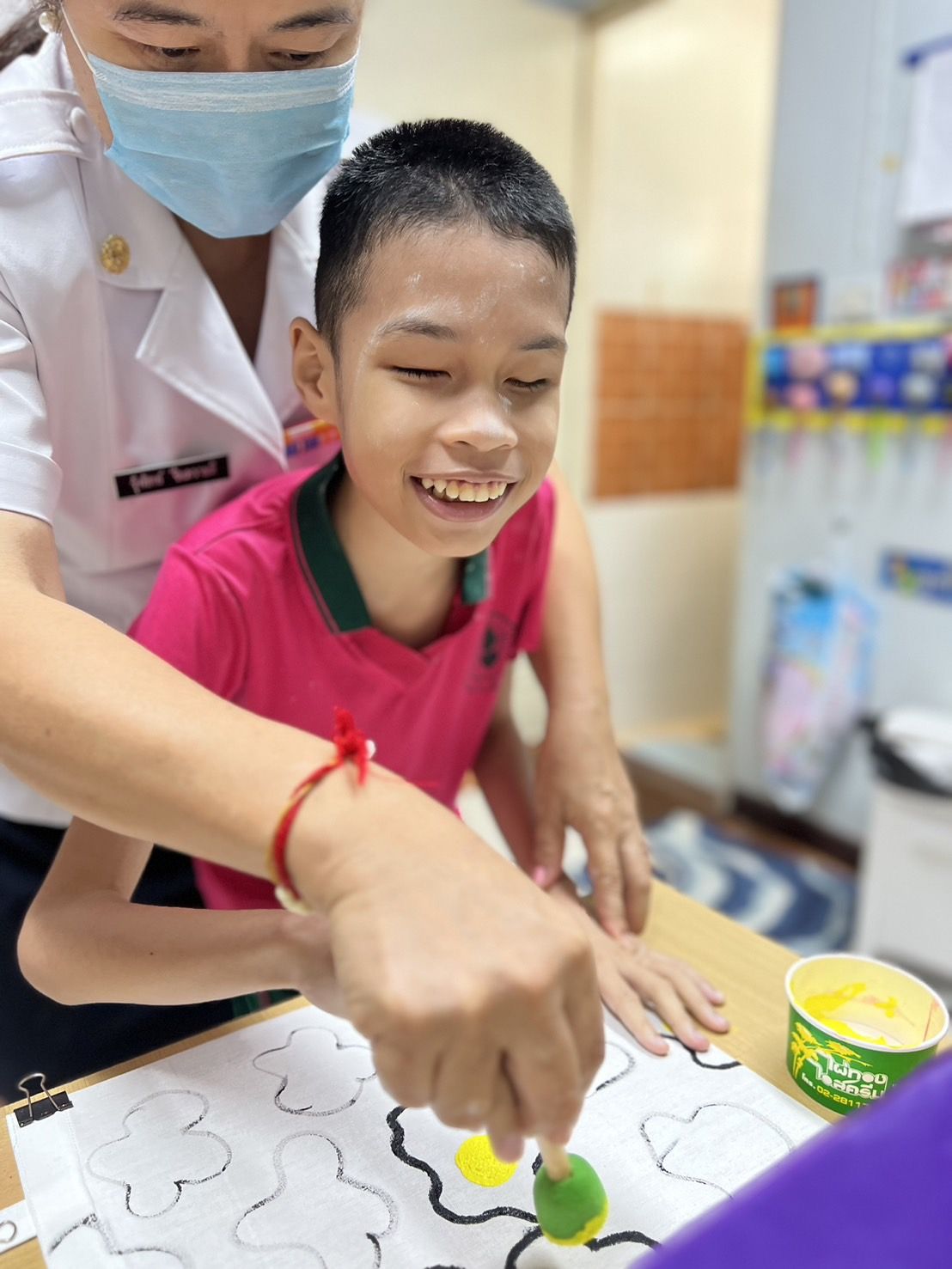 ครูจับมือนักเรียนปั๊มลายตามเส้น